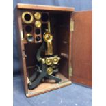 An early 20th Century brass antique microscope with accessories.