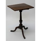 A George III oak tripod table, the rectangular snap top on a turned column, downswept legs and pad