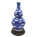 A Chinese double gourd shaped vase, decorated with Prunus pattern design, with a four character mark