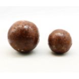 Two cast metal cannon shot balls.