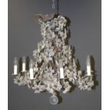 A pressed and wrought metal eight light electrolier with applied glass flowerheads. 60cm