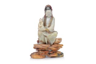 A SOAPSTONE MODEL OF GUANYIN WITH CHILD ON STAND