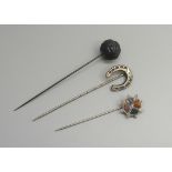 Three Victorian stick pins including carved French jet and Scottish hard stone