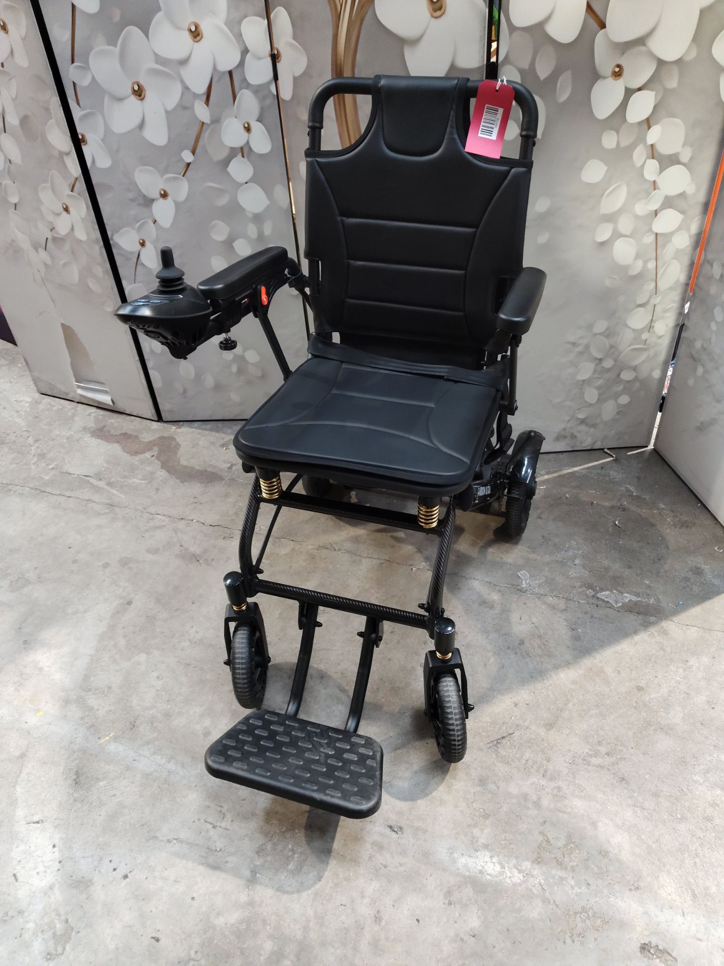 An as new carbon fibre lightweight foldable wheelchair.