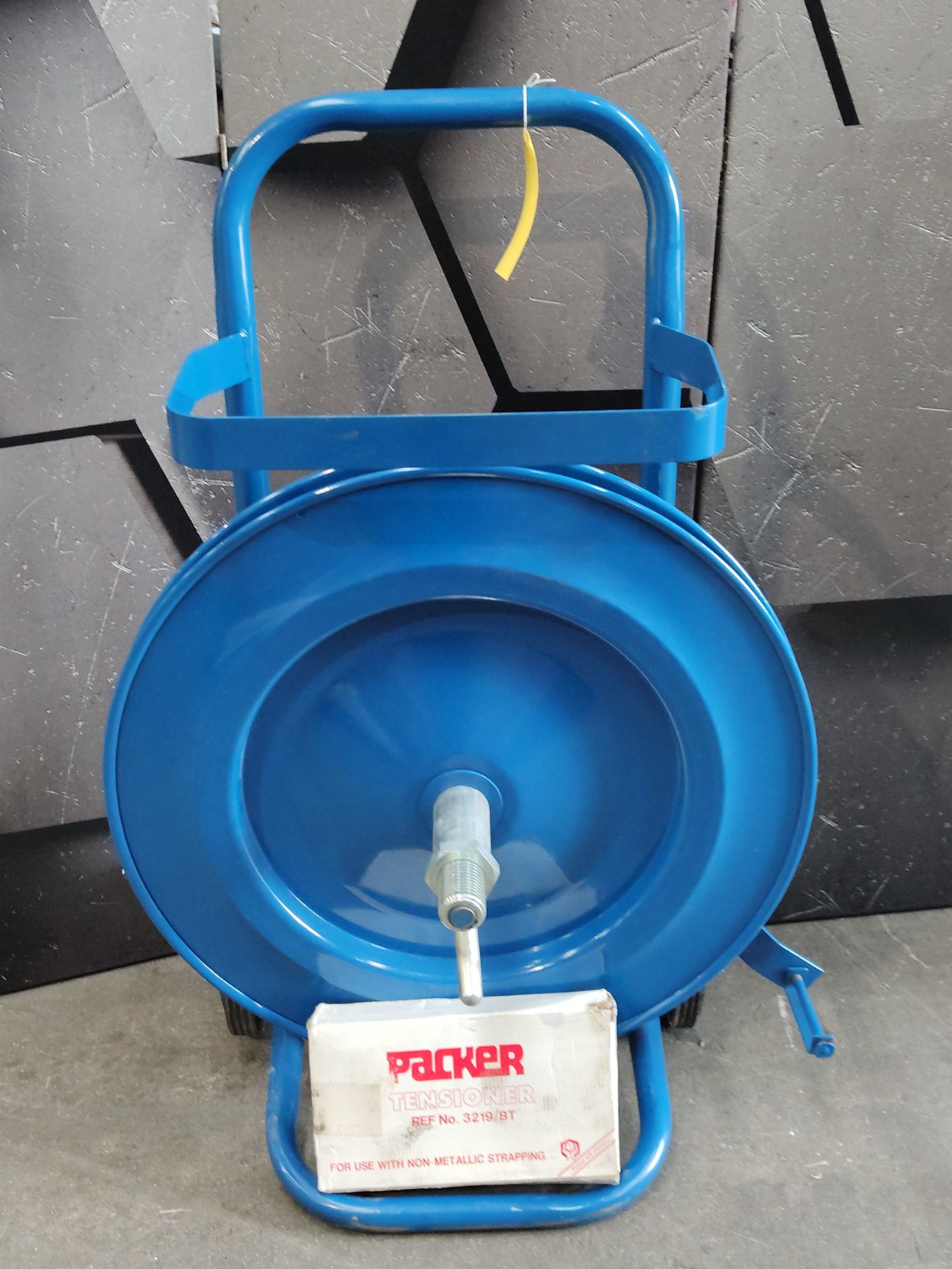 A pre-owned strap dispenser trolley in blue and a pallet strapping tensioner ratchet.