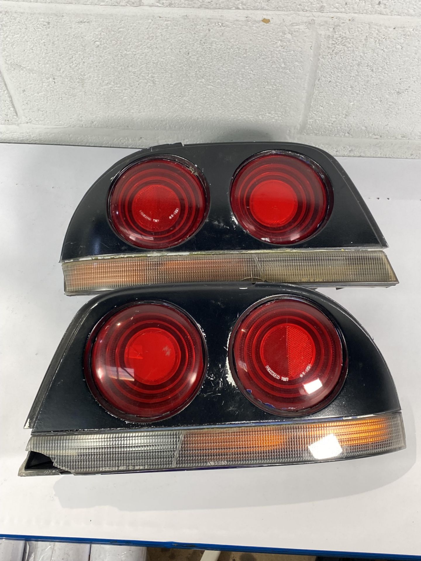 A pair of Nissan Skyline R33 taillights (requires repairing and repainting).