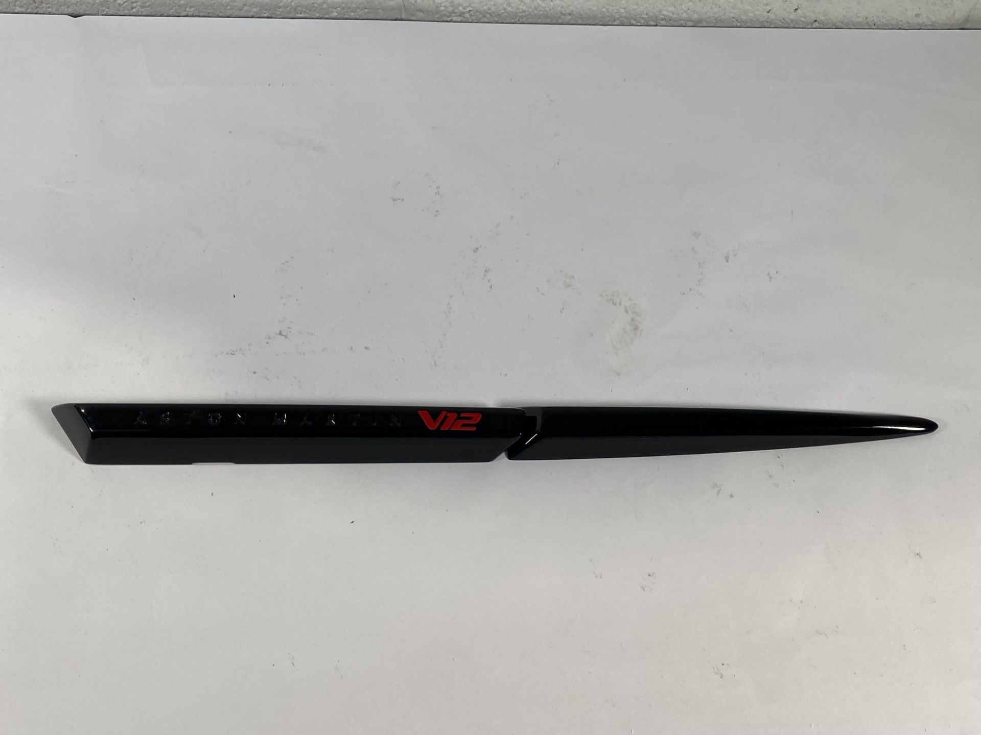 A gloss black left hand side strake assembly kit for a 2025 Aston Martin Vanquish Super GT V12.