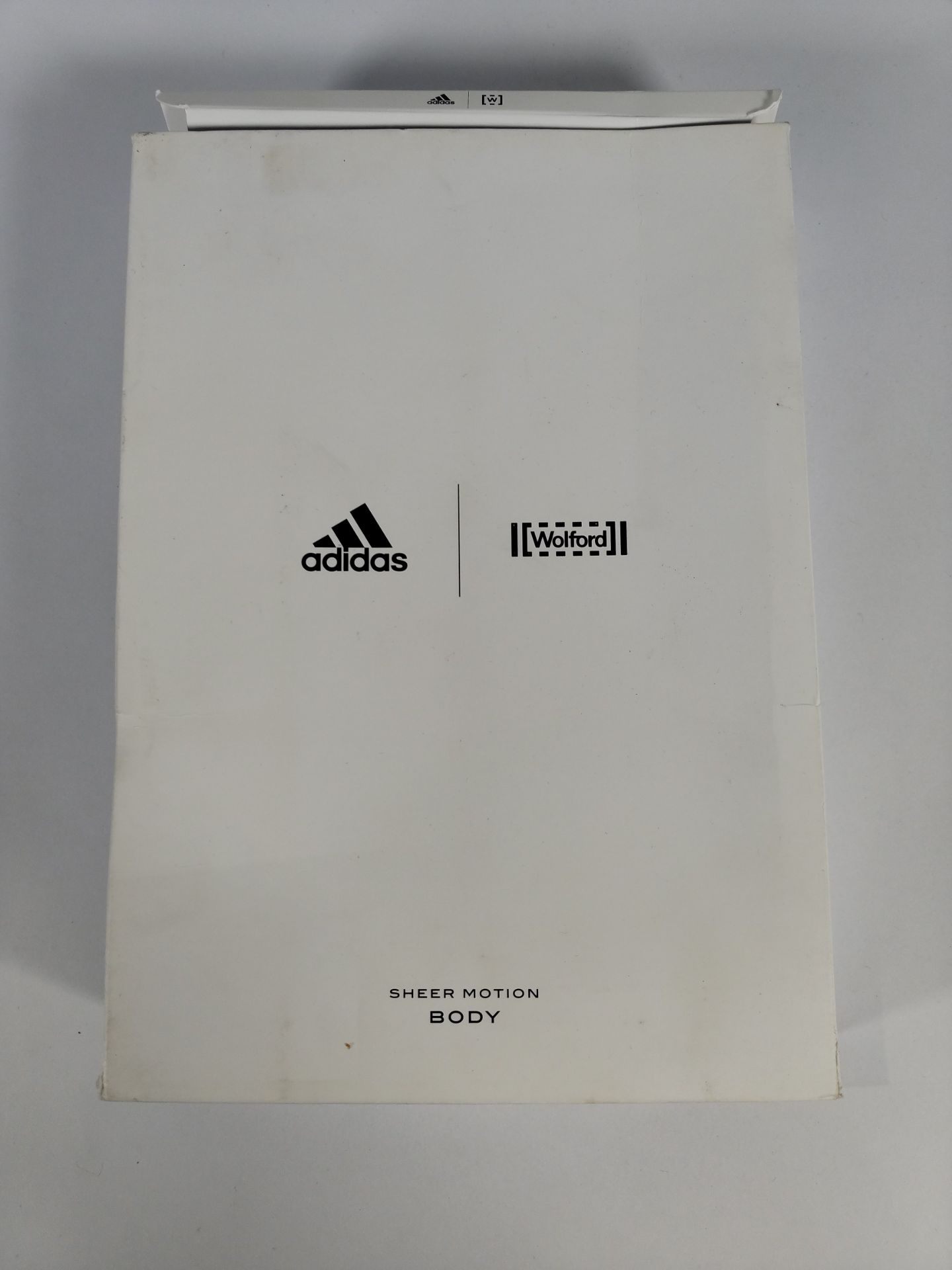 An as new Wolford x Adidas sheer motion body in nearly black/black (Size M).