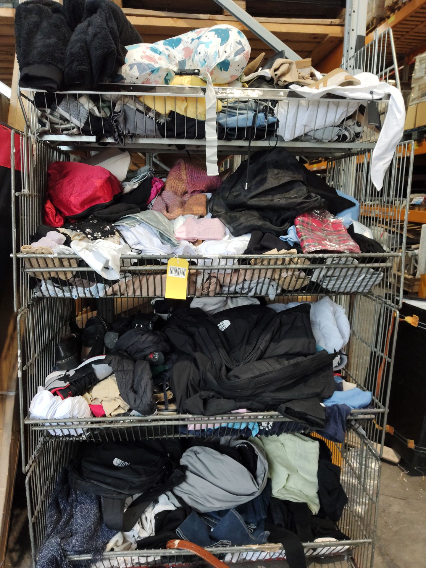 A large quantity of assorted as new and pre-owned clothing in four baskets.