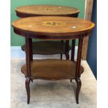A pair of oval Edwardian side tables with undershelves, each with marquetry inlay of a stand of