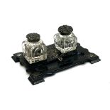 A Victorian black lacquered inkstand with mother of pearl inlay and two cut glass inkwells, 21cmW