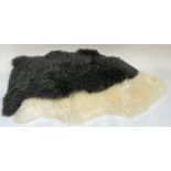 Two sheepskin rugs, one white, the other grey, each approx., 91cmL