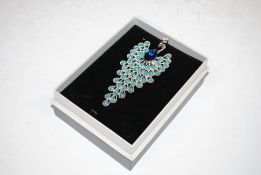 A costume brooch in the form of a peacock