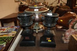 A pair of bronzed classical design Campana shaped urns on marble plinths