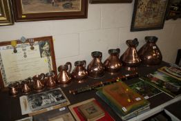 A harlequin run of antique copper pub measures ran