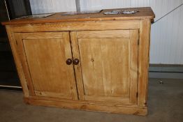A stripped pine cupboard fitted two doors