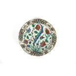 An Iznik pottery shallow dish, having foliate decoration; three Eastern pottery shallow bowls; a