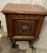 An early 20th century oak heavily carved single door cupboard with Green Man and foliage carving,