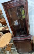 A mahogany corner cupboard with glazed upper door and single door to base,