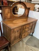 An early 20th century oak mirror-backed sideboard with three central drawers and cupboards to