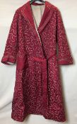 A cerise dressing gown with silver meandering embroidery,