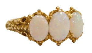 A 9ct gold and opal three stone ring, in a claw setting with beaded shoulders, size N1/2, 3.8g.