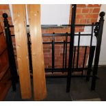 A cast metal king size bed frame, comprising headboard, footboard, side rails, and a slatted base.