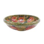 An early 20thC William Moorcroft pottery bowl, Pomegranate pattern, on green ground, signature