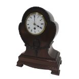 An Edwardian mahogany and walnut cased stylised balloon clock, of shaped form, with a raised garland