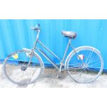 A mid-century ladies green Raleigh bicycle, with aluminium mud guards, pump, seat cover and electric
