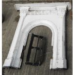 A late Victorian cast iron fire surround, with arch opening and later front grate, the surround