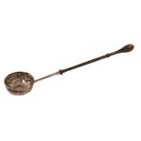A George III toddy ladle, with heavily repousse decorated bowl, centred by a coin, with turned