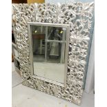 A large elaborate mirror, in silver, with pierced scroll border.