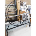 An iron double bed frame, with elaborate circular headboard, shaped footboard, slats and supports.