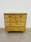 A Victorian waxed pine chest of two short over three long drawers
