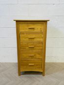 A tall and narrow solid 'blonde' oak contemporary chest of five drawers