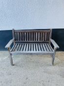 A weathered slatted hardwood garden bench.