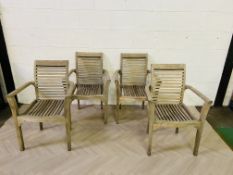 A set of four weathered hardwood patio chairs