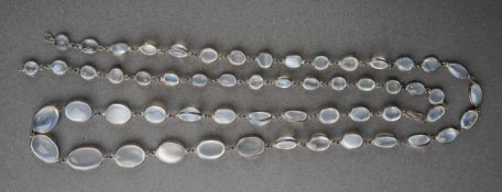 A long moonstone necklace. Designed as a series of graduating moonstone cabochons, spectacle set,