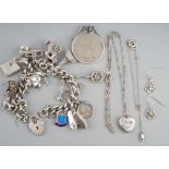 A collection of silver and white metal items. To include a silver charm bracelet, a silver heart