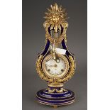 A V&A Museum Louis XIV style porcelain and brass mounted mantel clock, circular dial bearing Roman