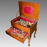 A 1940's oak veneered work table and contents, the hinged lid and fitted drawer containing reels