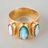 A yellow metal cameo ring. Set with three hardstone cameos to the plain band, stamped Kt14, approx