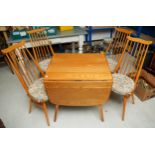 Ercol light elm drop leaf Windsor dining table with four spindle back chairs with padded upholstored