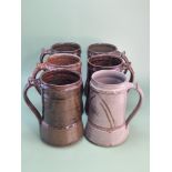Attributed to Michael Cardew, six brown and grey glazed mugs, the marks partially obscured by