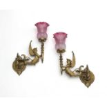 A pair of Victorian gilt metal and glass articulated wall lights, cast in the form of Harpies
