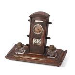 An Edwardian oak perpetual calendar cum desk tidy, with central clock to calendar and scrolling days