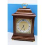 Boxed Garrard mantle clock with gilt dial, mounted on four bun feet, 25cm tall, with two-handled