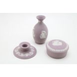Wedgwood Lilac Jasperware to include a candlestick, a lidded trinket and a vase, 12.5cm tall (3). In