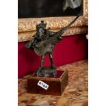 Standing Male musician dresses in a court style costume playing a long-necked flute/mandolin.